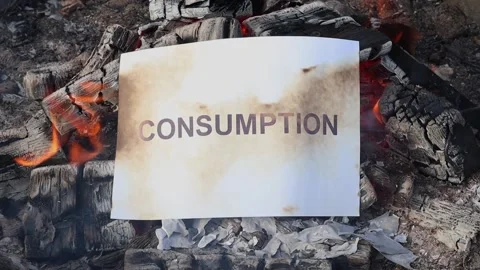 Word Consumption on a white sheet of paper burns into a fire against. Vídeos de archivo 141645238