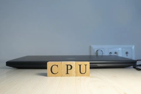 The word CPU is written. Computer and headset in the background. Closeup. Foto stock
