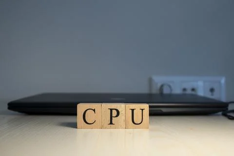 The word CPU is written. Computer and headset in the background. Closeup. Stock Photos