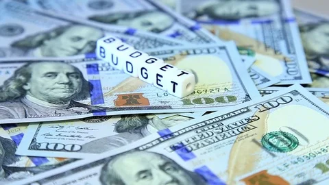 Word from cubes "budget" on the spinning surface of American dollars Video stock 70580868