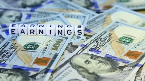 Word from cubes "earnings" on the spinning surface of American dollars. Stock Footage 70580691