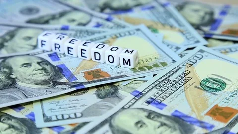 Word from cubes "freedom" on the spinning surface of American dollars Stock Footage 70580804