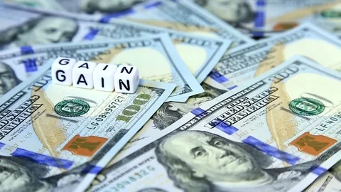 Word from cubes "gain" on the spinning surface of American dollars. Stock-Footage 70580510