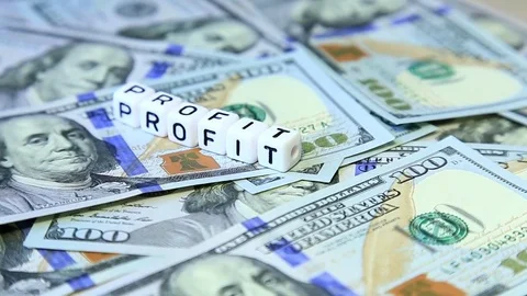 Word from cubes "profit" on the spinning surface of American dollars Stock Footage 70580604