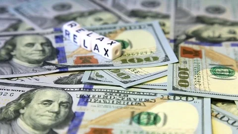 Word from cubes "relax" on the spinning surface of American dollars Stock Footage 70580851
