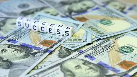 Word from cubes "success" on the spinning surface of American dollars. Stock-Footage 70580611