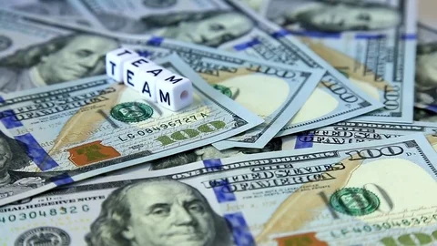 Word from cubes "team" on the spinning surface of American dollars. Stock Footage 70580841