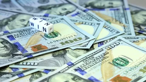 Word from cubes "win" on the spinning surface of American dollars Stock Footage 70580843