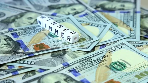Word from cubes "winner" on the spinning surface of American dollars. Stock Footage 70580859