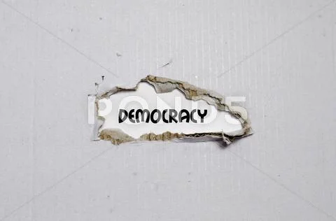 The word democracy appearing behind torn paper Stock Photos