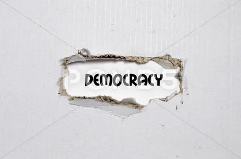 The word democracy appearing behind torn paper Stock Photos