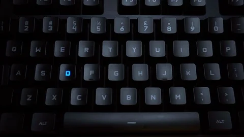 The word detective is typed on a luminous computer keyboard. Black backlit Stock Footage 118276425