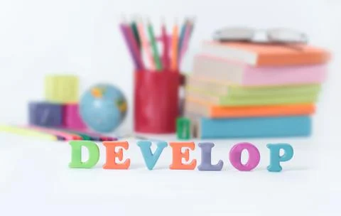 Word develop on blurred background of school supplies .photo with copy space Stock Photos
