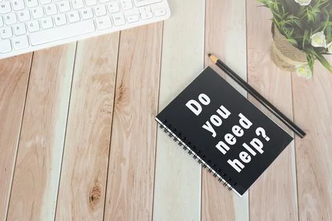 Word DO YOU NEED HELP on notepad on wooden desk. Stock Photos