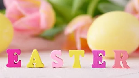Word Easter is made up of multicolored letters on background of flowers and E Stock Photos