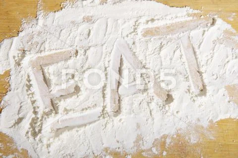 The word 'eat' written in flour Stock Photos