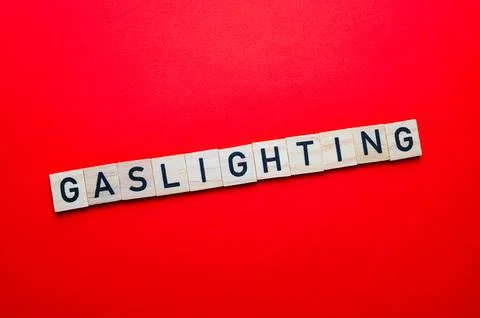 Word Gaslighting on red surface. Stock Photos