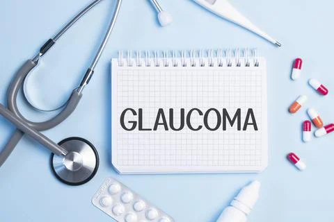 The word GLAUCOMA written on a white notepad on a blue background near a stet Stock Photos