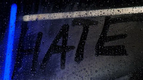The word hate, written with a finger, on a misted night window Stock Footage 221919483