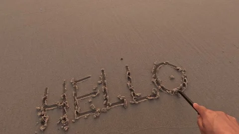The word "Hello" is written by hand on the beach sand 스톡 동영상 245709448