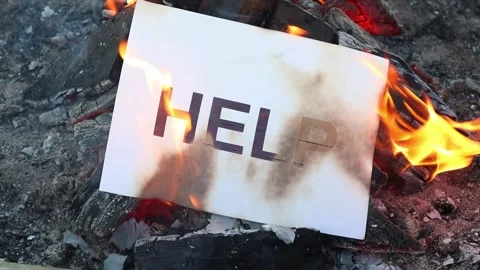 Word Help on a white sheet of paper burns into a fire against. Slow motion Vídeo Stock 138591623