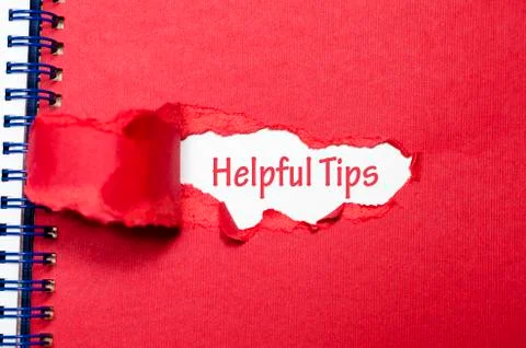 The word helpful tips appearing behind torn paper Stock Photos