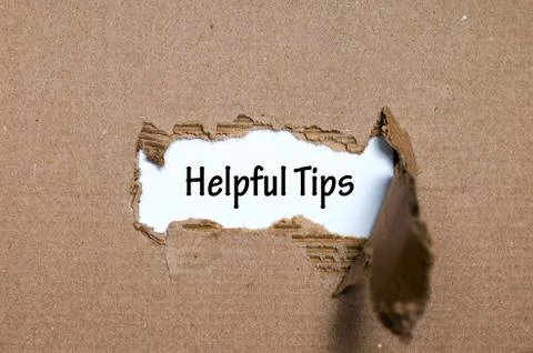 The word helpful tips appearing behind torn paper Stock Photos