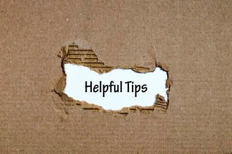 The word helpful tips appearing behind torn paper Stock Photos