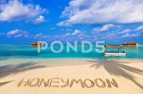 Word Honeymoon on beach Stock Photos