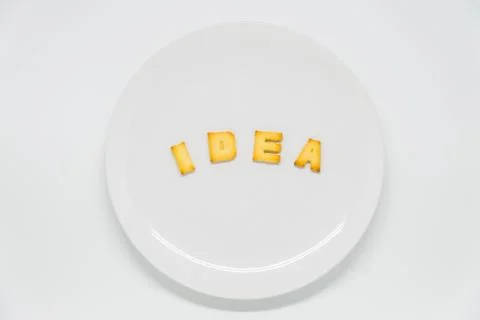 Word IDEA cracker on dish with white background Stock Photos