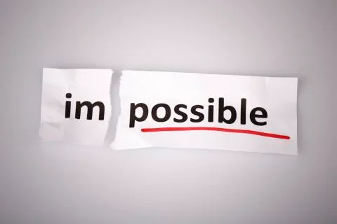 The word impossible changed to possible on torn paper and white background Stock Photos