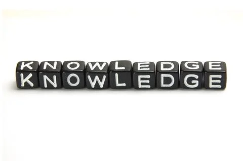 The word Knowledge on the black dice isolated on white background Stock Photos