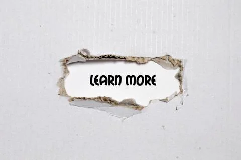 The word learn more appearing behind torn paper Stock Photos