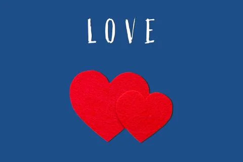 The word love on a blue background. Two red hearts on an isolated background. Ilustração Stock