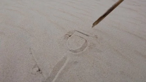 The word love. Tool is tracing patterns in fine sand, capturing the gradual Stock Footage 317041598