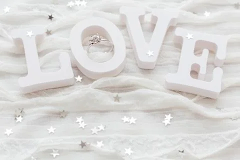 Word LOVE on white fabric background with engagement diamond ring. Good for V Foto stock