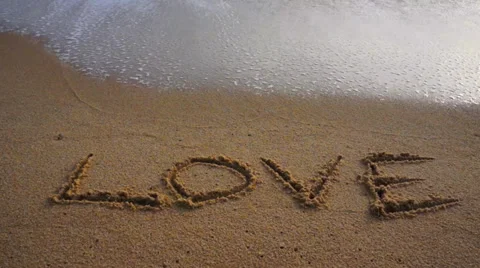 Word LOVE written on sand beach. Stock Footage