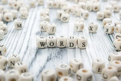 Word made with block wood letter next to a pile of other letters over the wooden Stock Photos