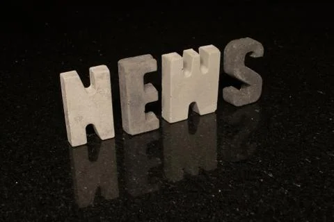 Word News as grey concrete letters on black tile Stock Photos