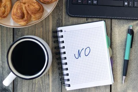 Word NO in notebook on the working table with cup of coffee and bun. Job recr Stock Photos