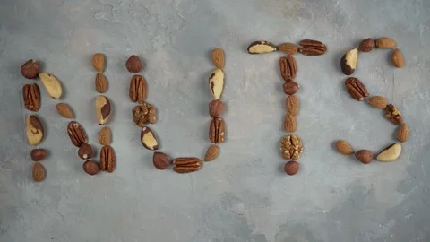 The word nuts from a mixture of nuts on a light gray background. Stock Footage 167567987