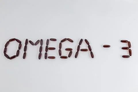 Word OMEGA 3 made of cod liver oil capsules on white background Stock Photos