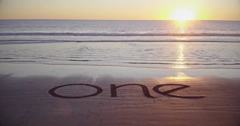 The word one on the beach in the sand during sunset Stock Footage 58649712
