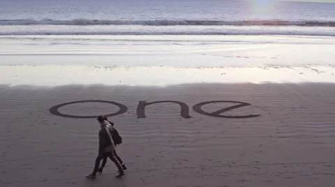The word one writing in the sand during sunset Video stock 58649697