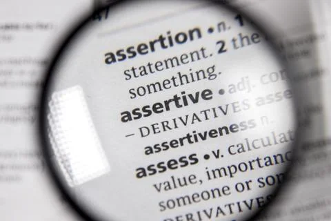 The word or phrase assertive in a dictionary. Stock Photos
