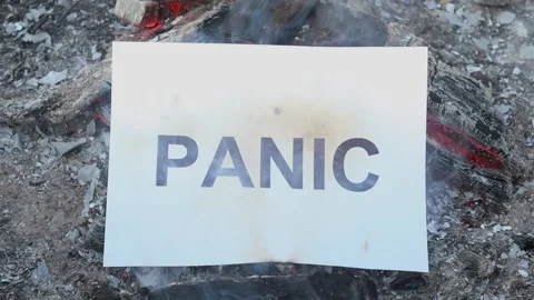 Word Panic on a white sheet of paper burns into a fire against. Slow motion Vídeo Stock 138654138