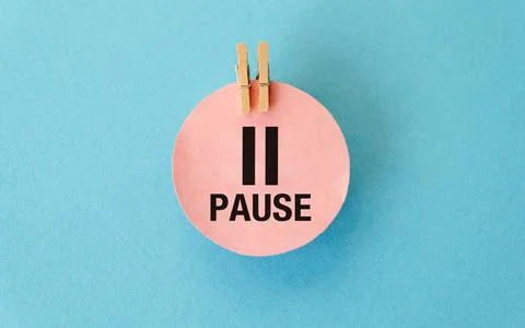 The word Pause on a round pink sticker on a blue background Stock Photos