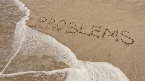 Word "problems" written in sand on the beach and washed by waves Stock Footage 245709455