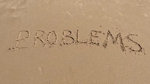 Word "problems" written in sand on the beach and washed by waves 動画素材 245710266
