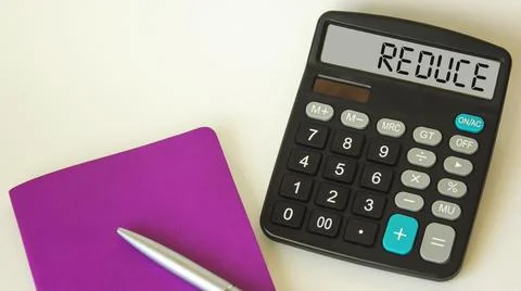 The word REDUCE on the calculator. Cost optimization business concept. Stock Photos